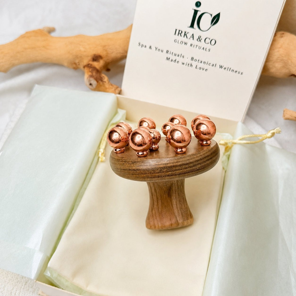 Copper cluster massage tool standing upright in its gift box, copper balls facing up