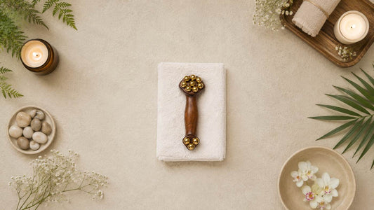 Gua sha massage tool styled on a spa flat-lay with candles, stones, and flowers