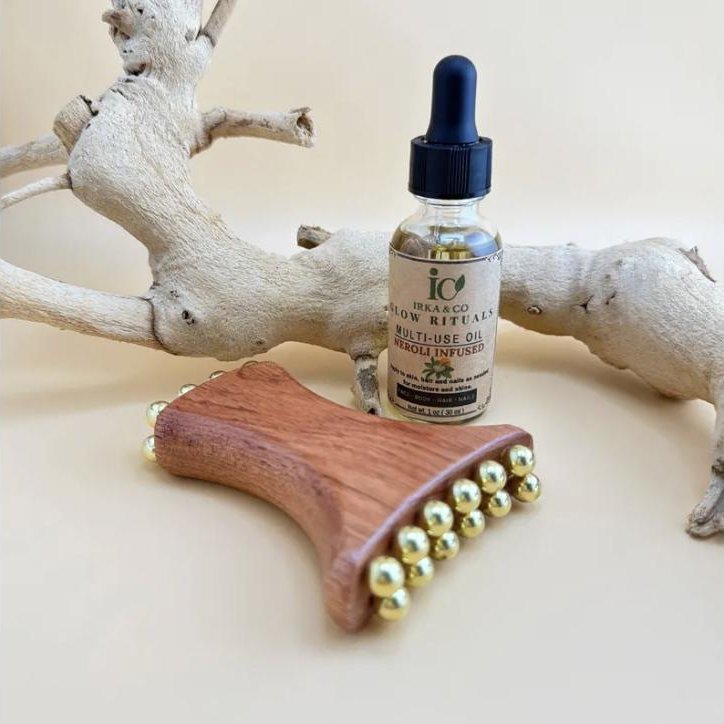 Handcrafted wood and brass gua sha tool for jawline and neck massage from Irka & Co Glow Rituals