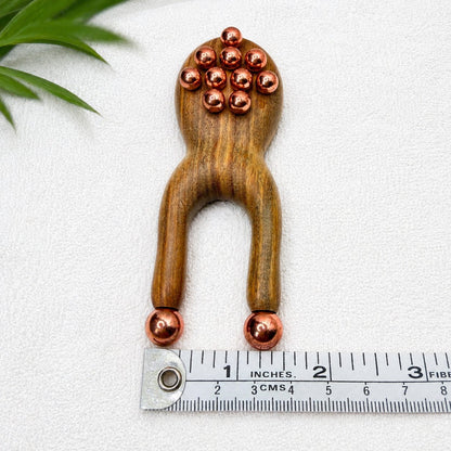 Green sandalwood facial lift massager shown upright next to a ruler measuring 4 inches long