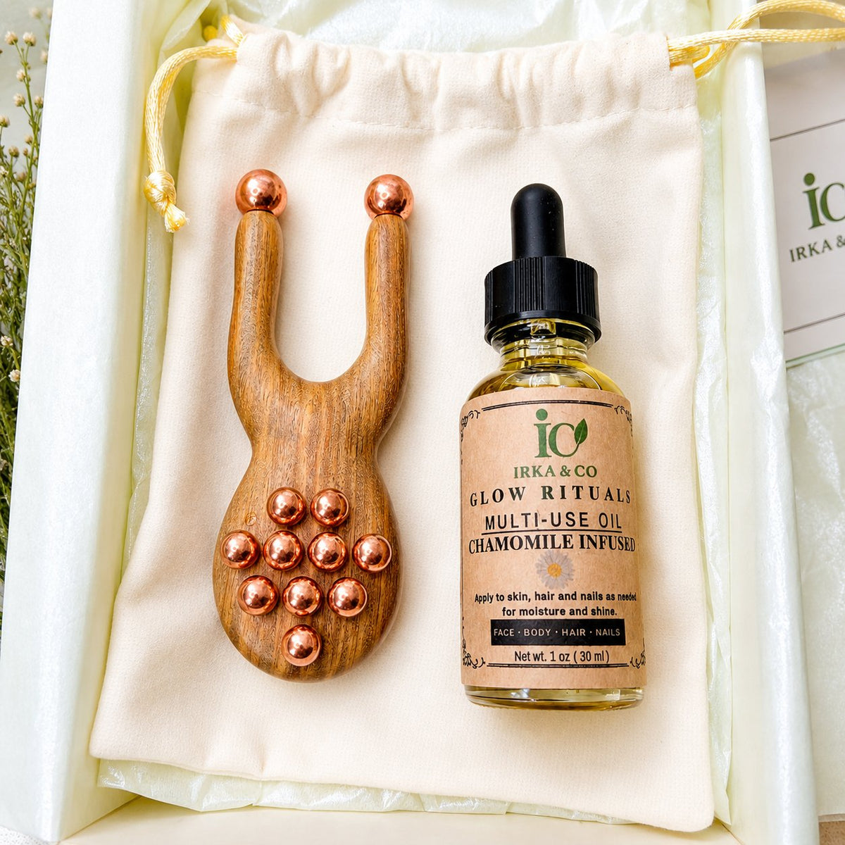 Copper and green sandalwood facial massager displayed with a bottle of botanical facial oil