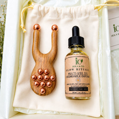 Copper and green sandalwood facial massager displayed with a bottle of botanical facial oil