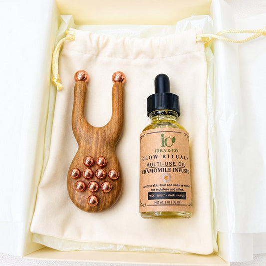 Gift box open to show the facial lift massager with a botanical facial oil bottle tucked inside