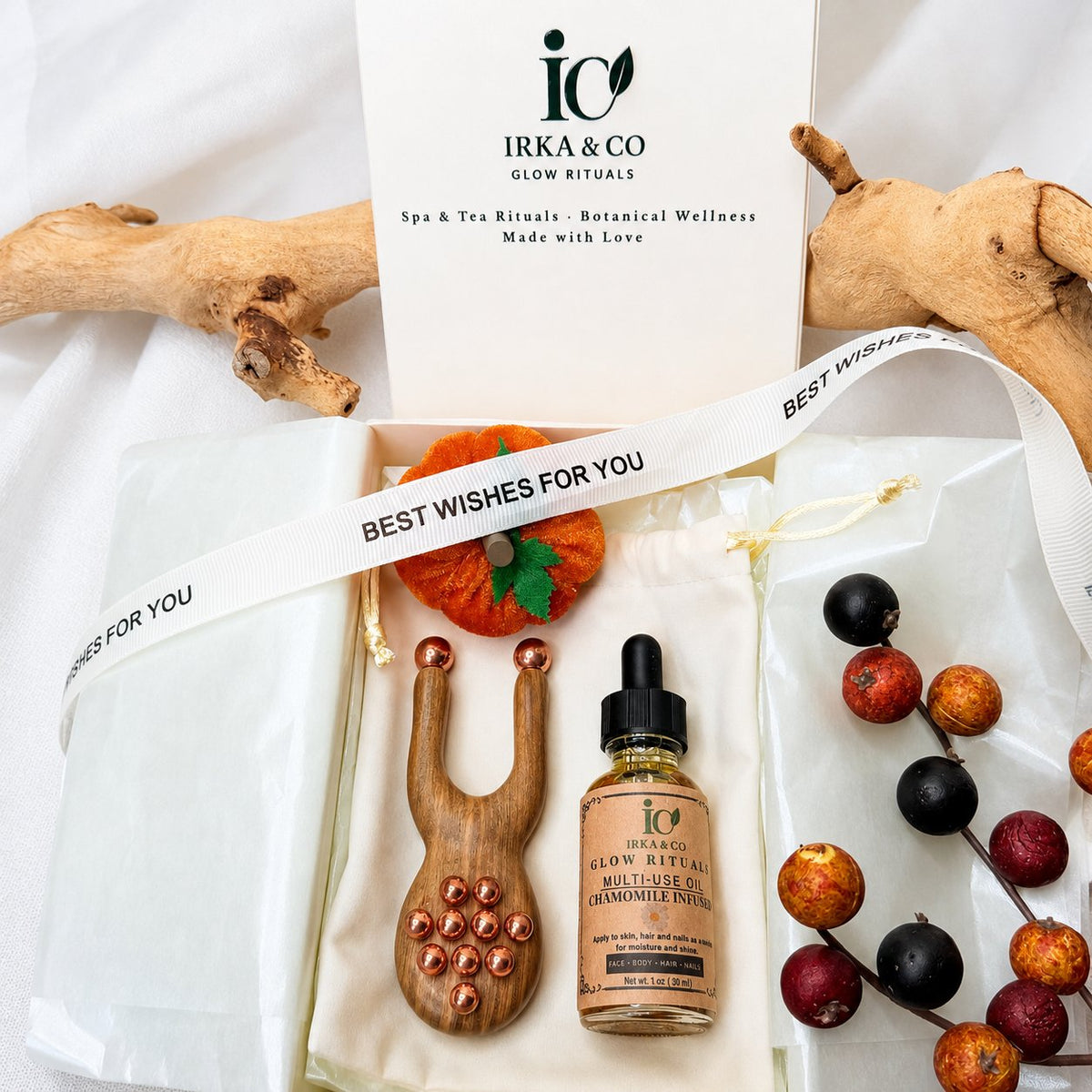 Gift-wrapped box with a Best Wishes ribbon in a flat lay with the copper facial lift massager