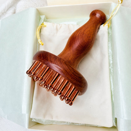 Copper & Rosewood Deep Tissue Massager resting on its cotton pouch inside the Irka & Co gift box