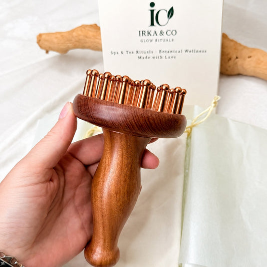 Copper & Rosewood Deep Tissue Massager held in hand with the Irka & Co Glow Rituals gift card behind it