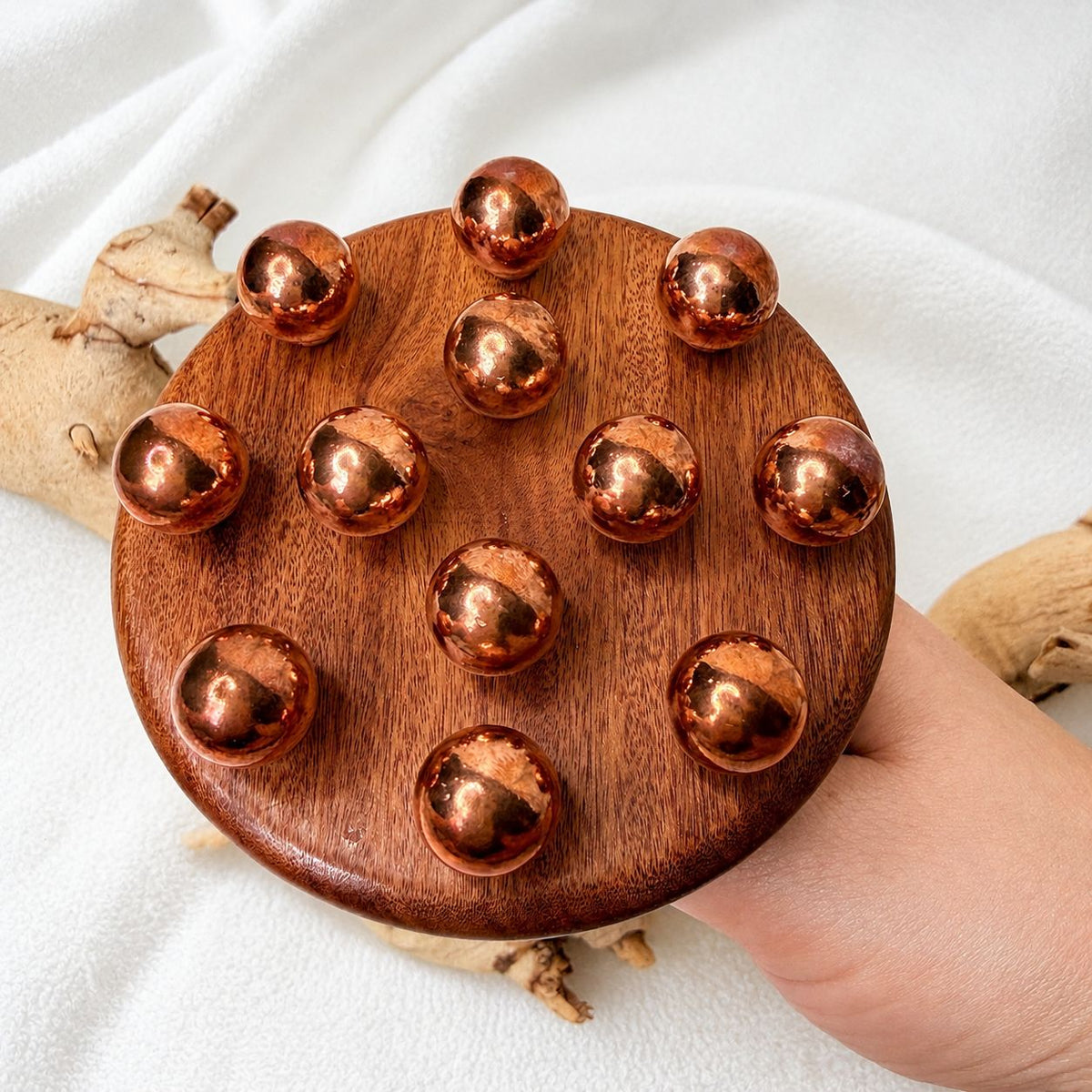 Close-up of the copper bead cluster head of the body contouring massage tool held in hand