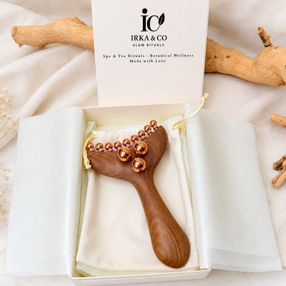 Copper & Wood Deep Tissue Massage Tool in an open IRKA & CO gift box with branded insert card, styled with driftwood on a cream cloth