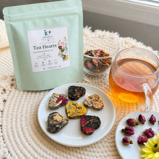 Irka & Co Tea Hearts pouch in sage green with a cup of freshly brewed tea and heart shaped tea hearts on a small plate