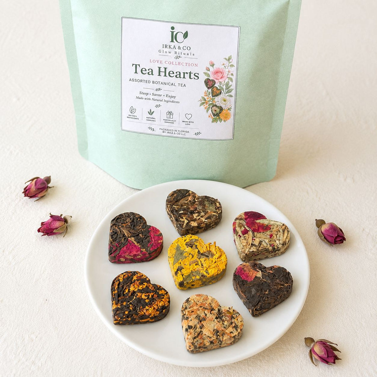 Irka & Co Tea Hearts pouch with seven heart shaped teas and dried rose buds on a white plate