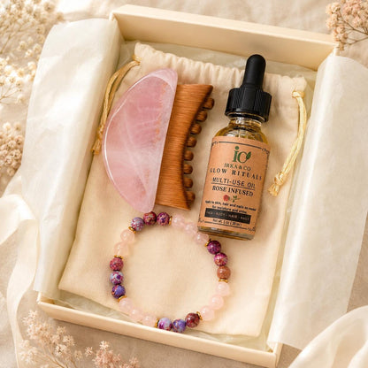 Close-up top-down view of the Rose Quartz Gua Sha Ritual Set inside its gift box on a cream pouch, styled with dried baby's breath