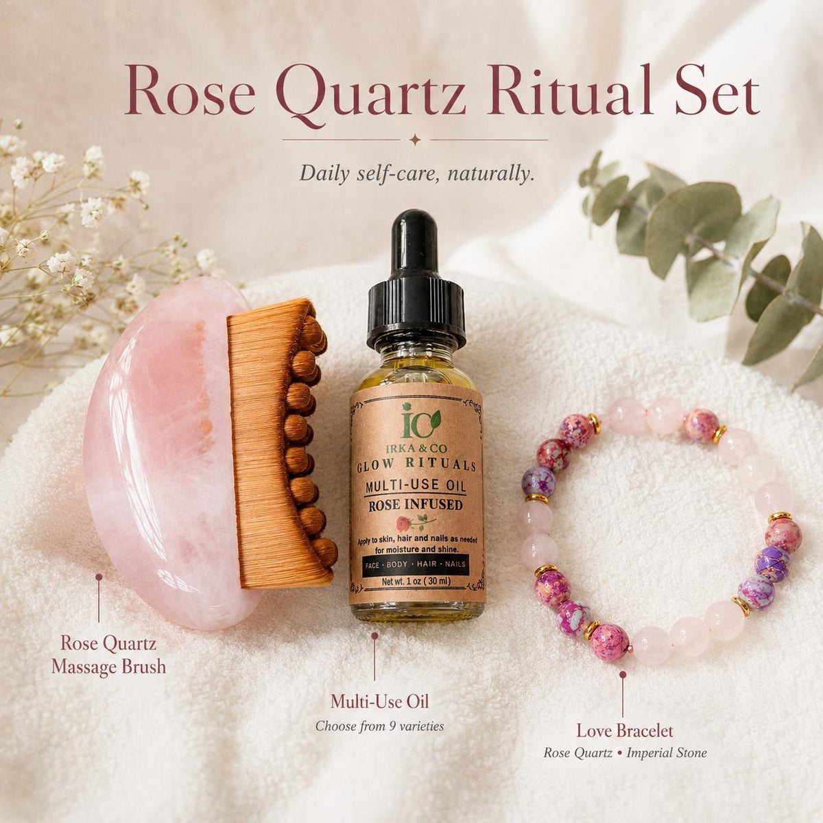 Labeled Rose Quartz Ritual Set flat lay identifying the Rose Quartz Massage Brush, Multi-Use Oil, and Love Bracelet on a white towel with eucalyptus