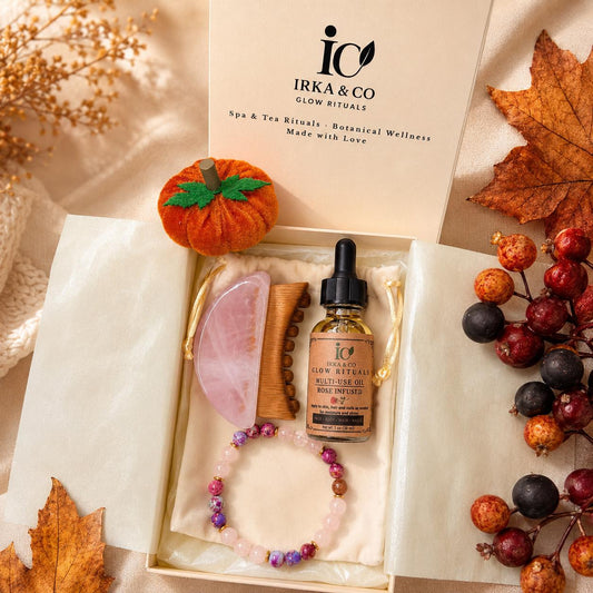 Rose Quartz Ritual Set gift box styled with autumn leaves, berries, and a felt pumpkin, showing the gua sha, comb, oil, and bracelet