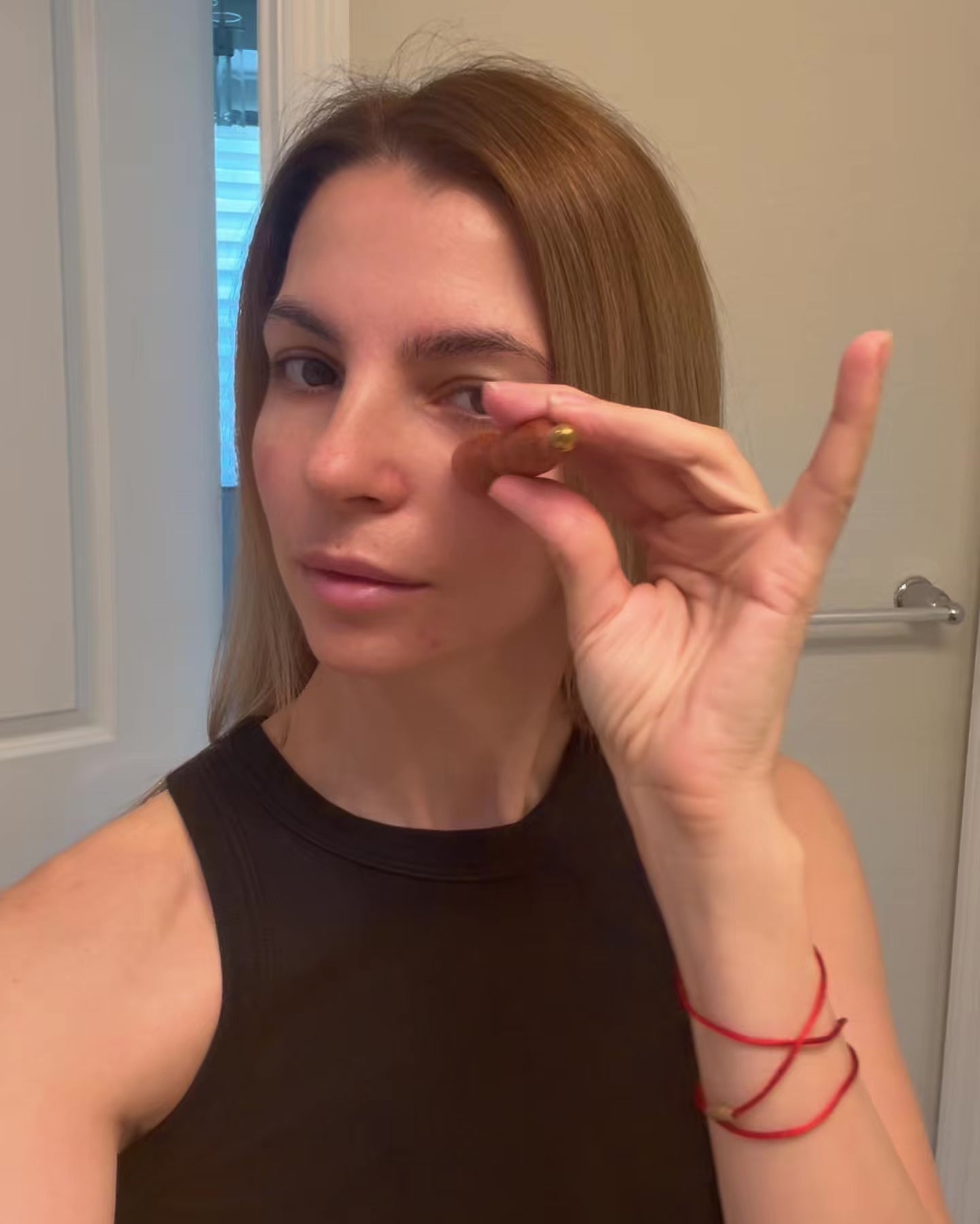 Video of a woman holding the Small Lotus Facial Roller up near her eye, demonstrating its compact size