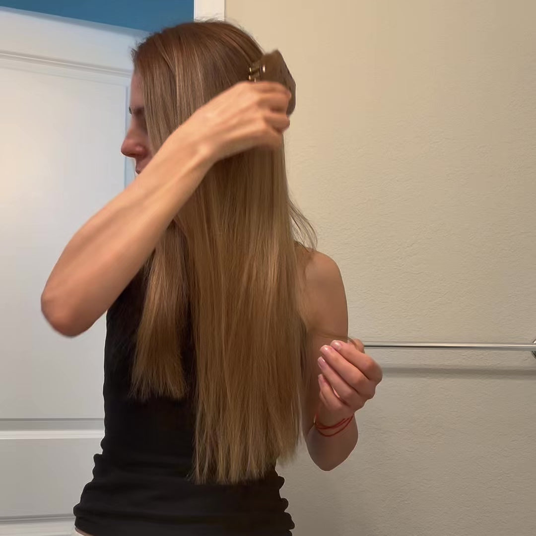 Video of a woman demonstrating a wooden scalp and hair massage tool from the Ultimate Wellness Ritual Box through her hair at the roots