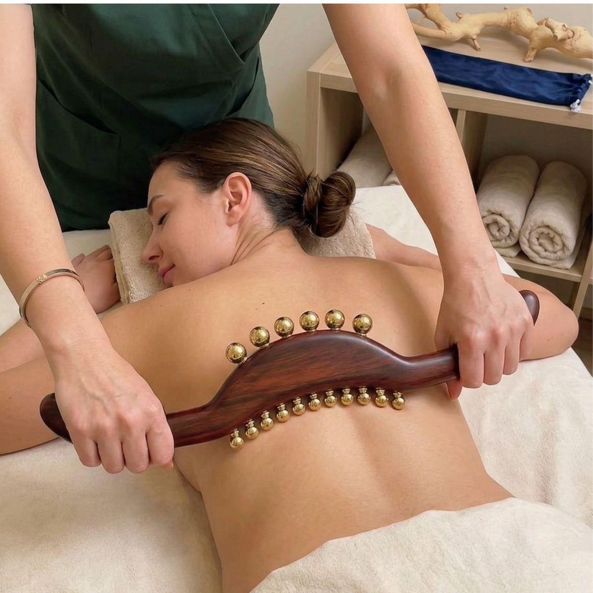 Woman receiving a back massage with the wood and brass Full Body Lymphatic Drainage Massage Wand, styled for a self-care ritual